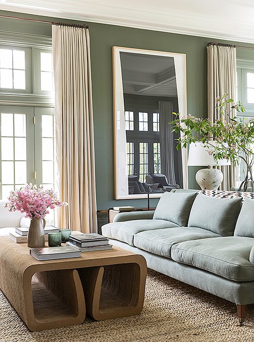 The muted green sofa, and even the darker green walls, are neutrals in keeping with the rest of the room. Photo by Lesley Unruh.
